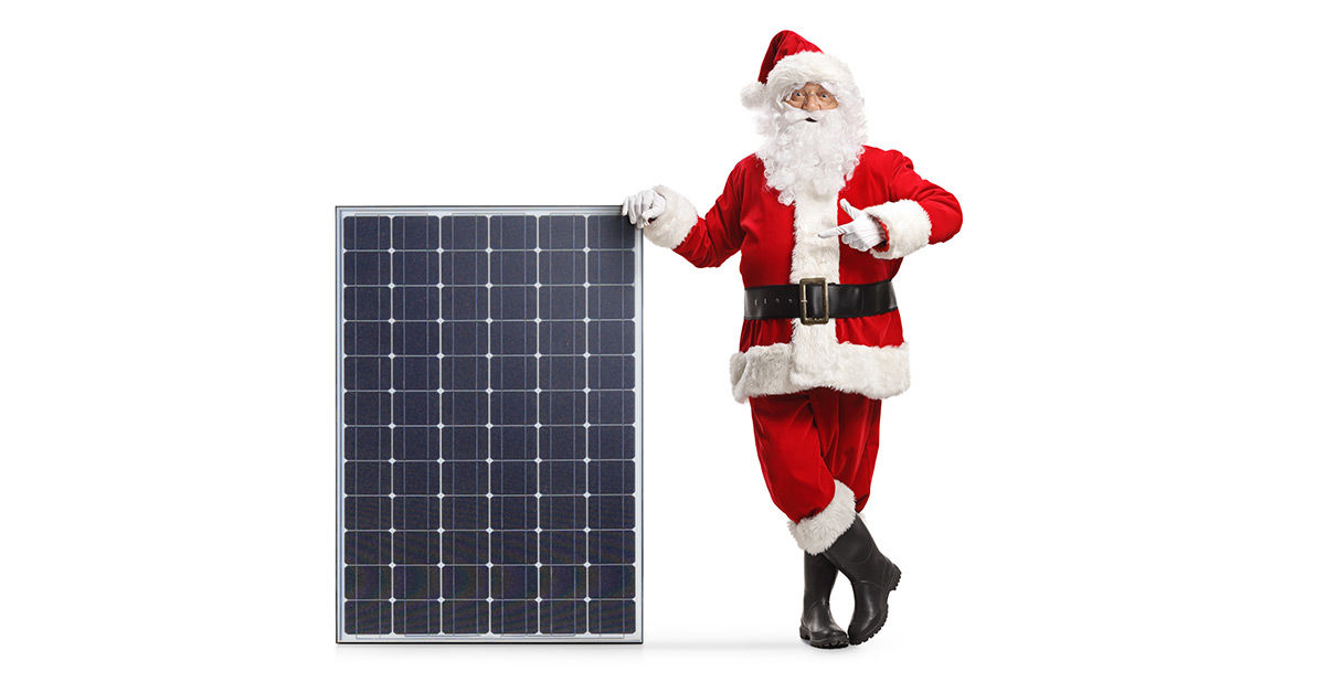 Ein Weihnachtsmann lehtn an einer Photovoltaikanlage - Weihnachtsgrüße
